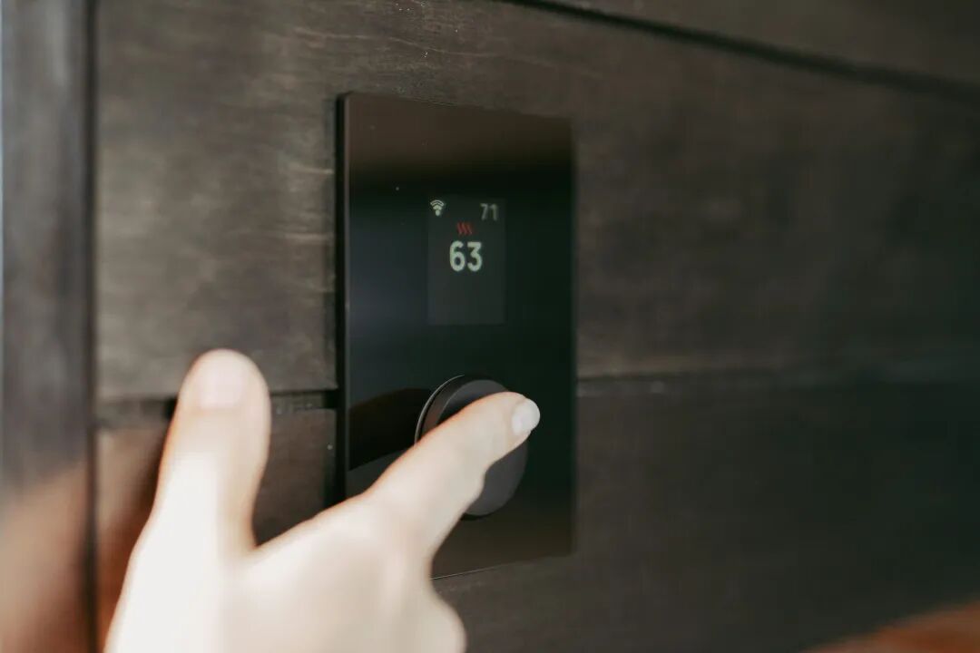 Hand adjusting a digital thermostat display